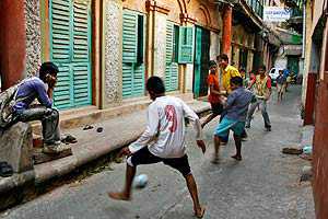 Street soccer played by barefoot children 